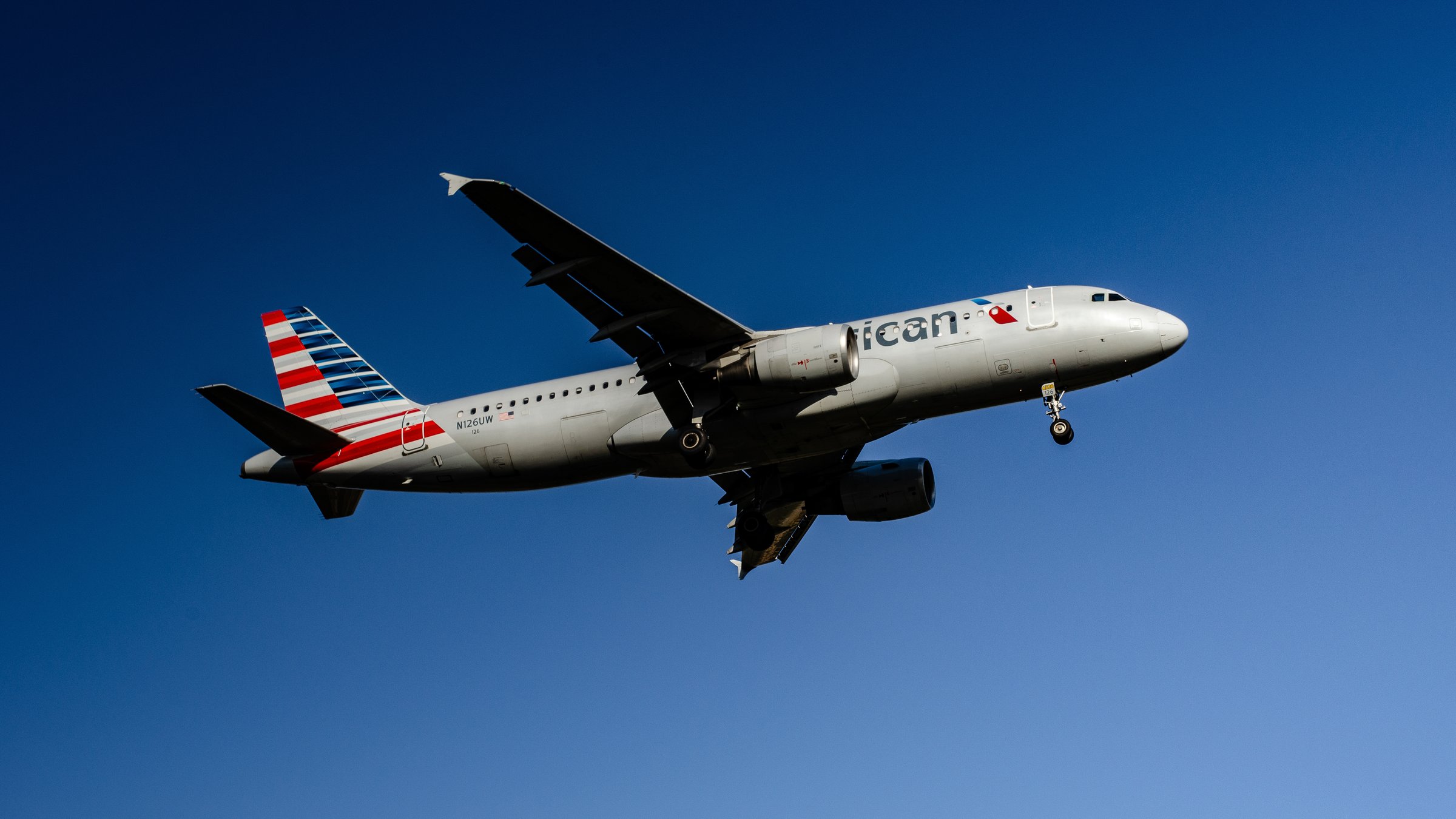 American Airlines aircraft in flight against deep blue sky